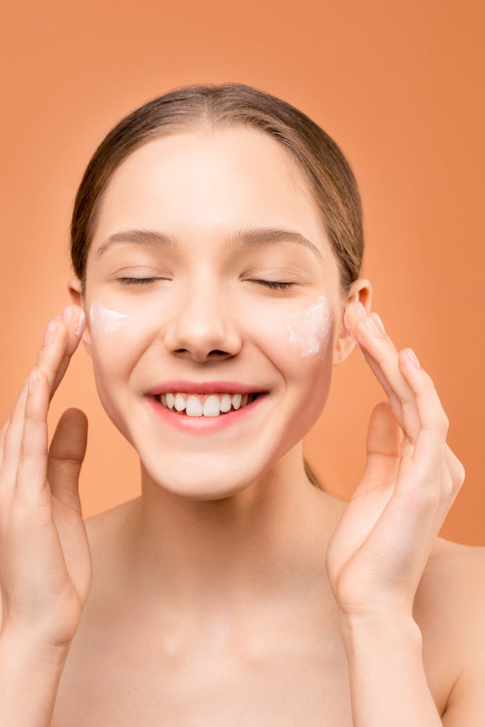 digital A cheerful woman applies face cream as part of her skincare routine, promoting health and beauty.