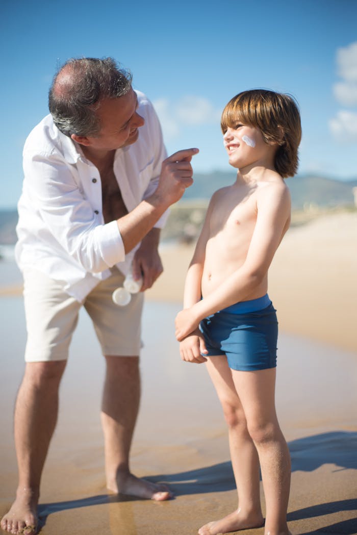 creative A joyful moment between father and son applying sunblock at a sunny beach.
